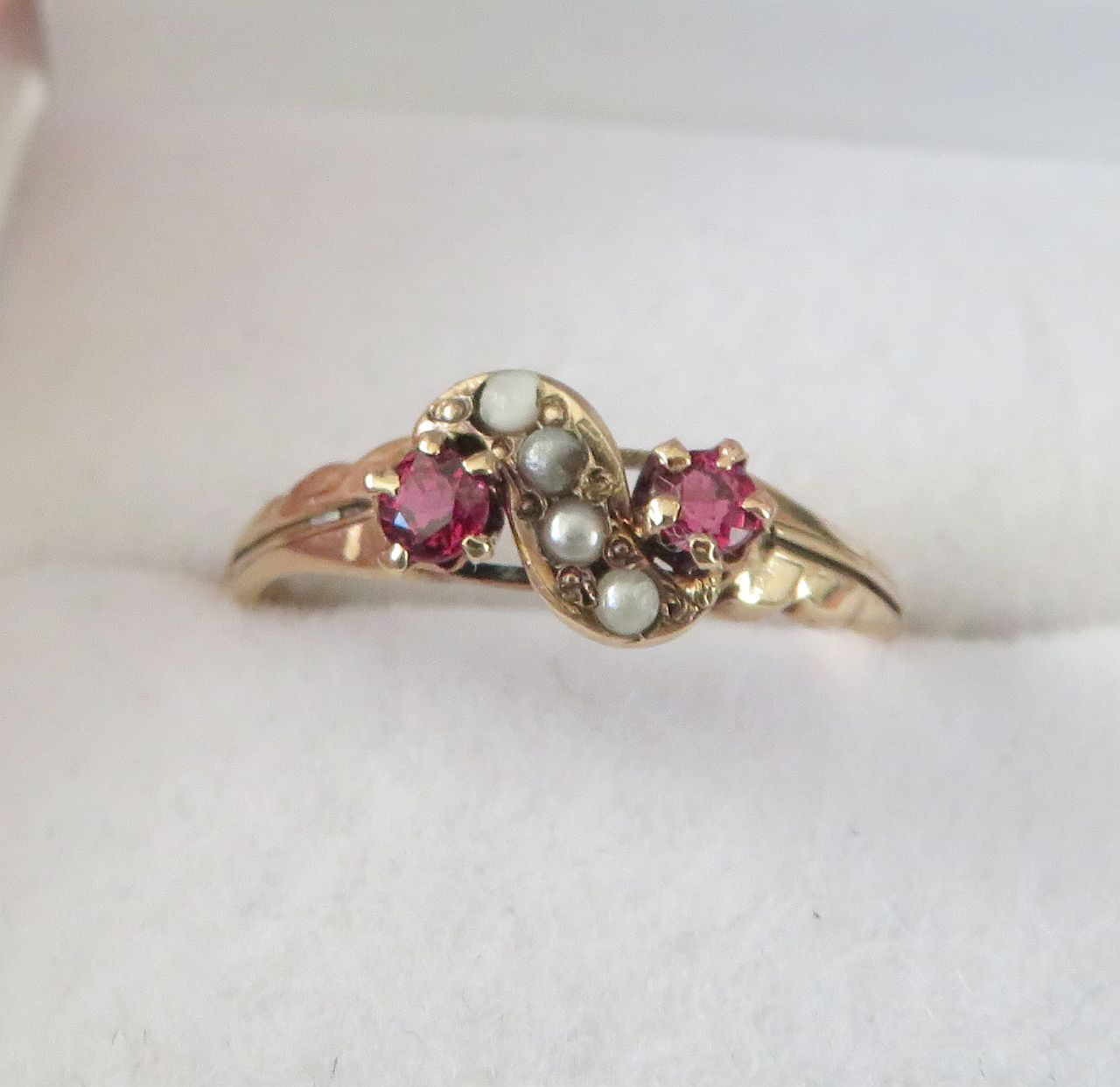 1930s Hammerman Brothers garnet and seed pearl crossover gold ring, front view in jewellery box